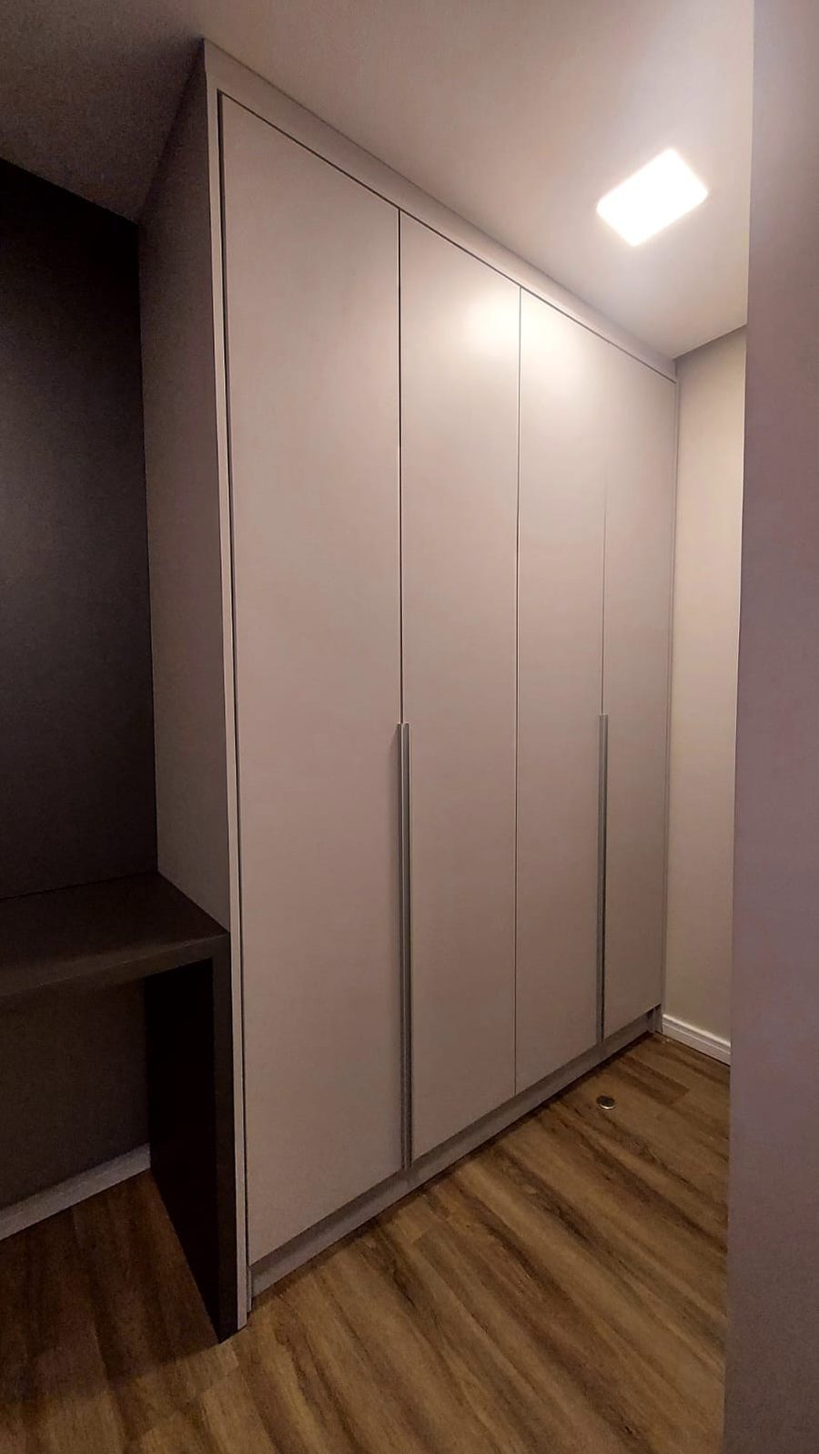 Closet com quatro portas e banco escuro embutido