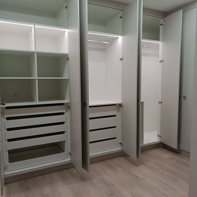 Closet aberto mostrando prateleiras, gaveteiros e fita de LED por dentro