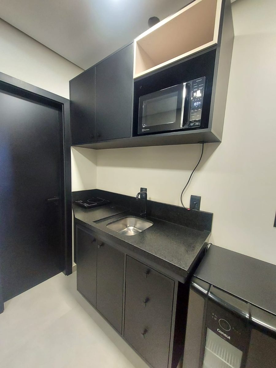 Copa compacta com armário preto, cooktop, microondas e frigobar