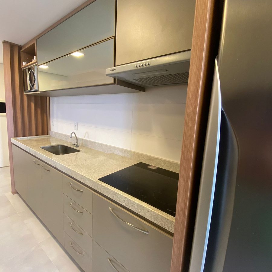 Cozinha planejada cinza vista de lado, com cooktop e coifa