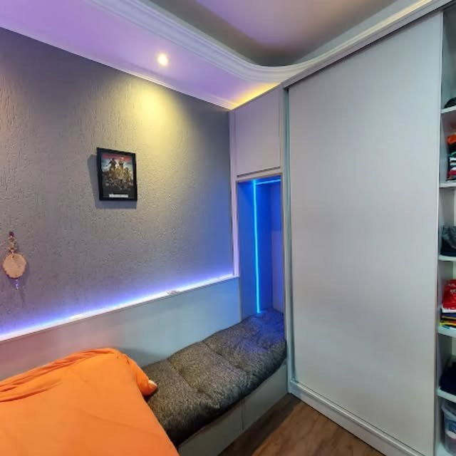 Dormitório com guarda-roupa de porta de correr e nicho iluminado sobre a cama
